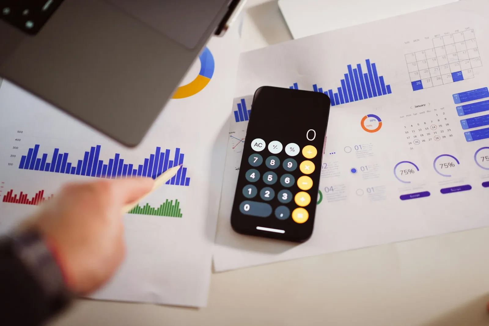 Calculatrice posée sur des graphiques et tableaux de budget